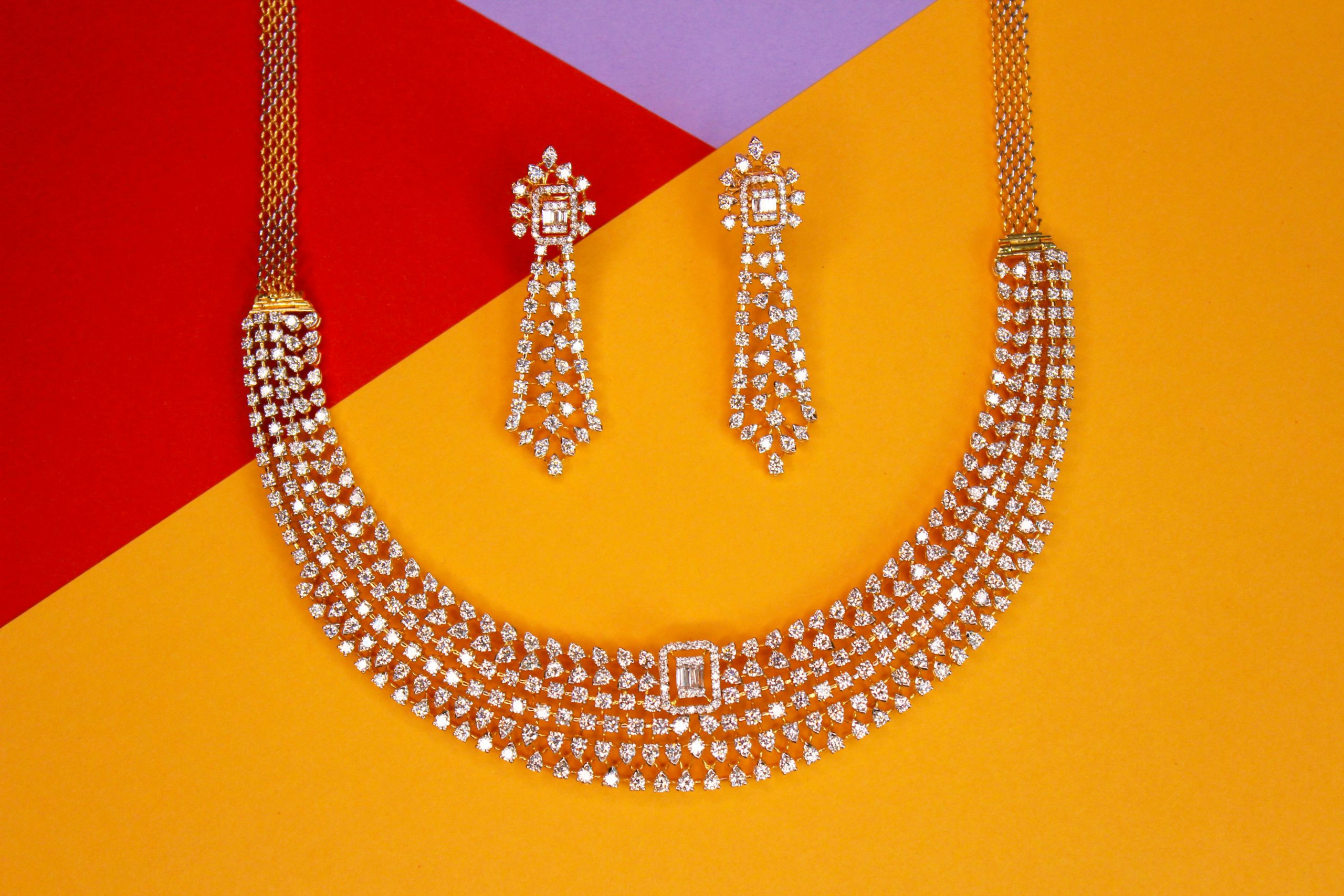 Close-up of luxurious diamond necklace and earrings set against a vibrant background, showcasing elegance and glamour.